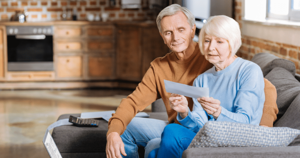 older couple sits together and looks at their mail